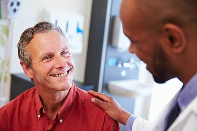 Doctor Looking Down To Smiling Man In Red